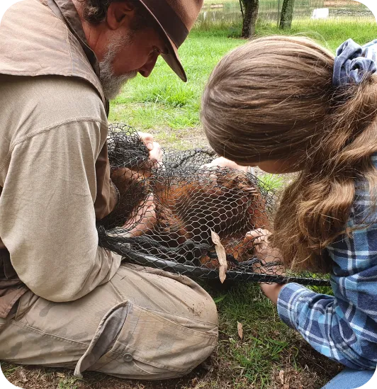 John Creighton and volunteer helping an animal